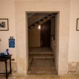 Mentre parliamo, madre e figlio ci conducono all�interno dell�edificio attraverso una porticina situata alla sinistra del portale d�ingresso. Ci ritroviamo quindi in un piccolo atrio...